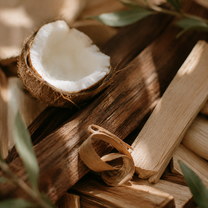 Coco Santal coconut wax candle ingredients, coconut and teakwood on wood